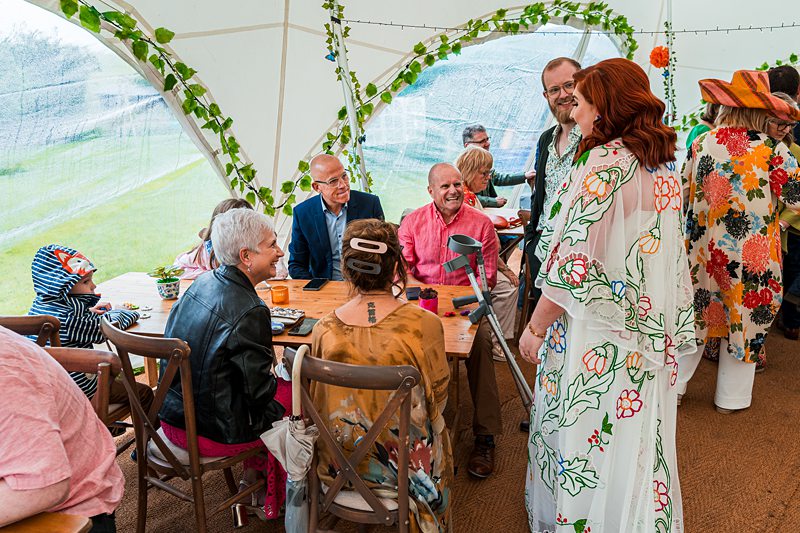 People enjoying a garden party in a marquee.