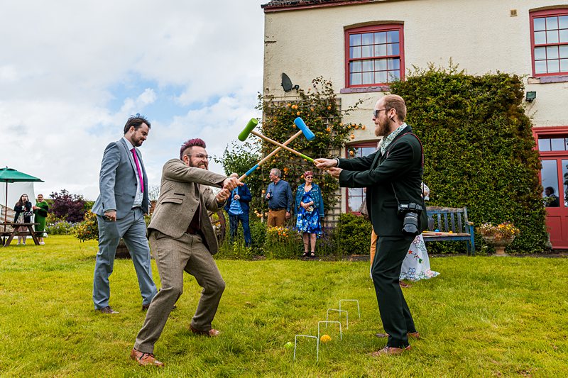 People playing croquet at outdoor event.