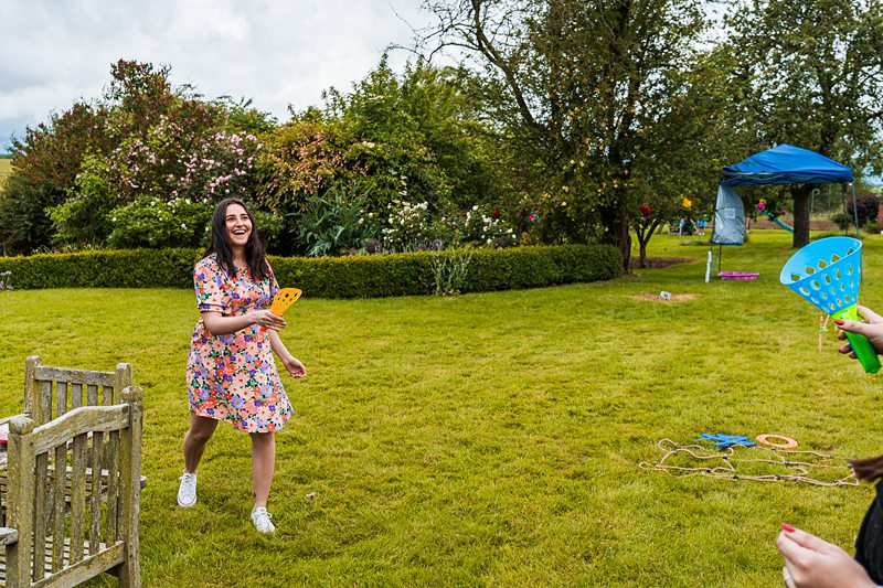 Woman playing garden game in a colourful dress.