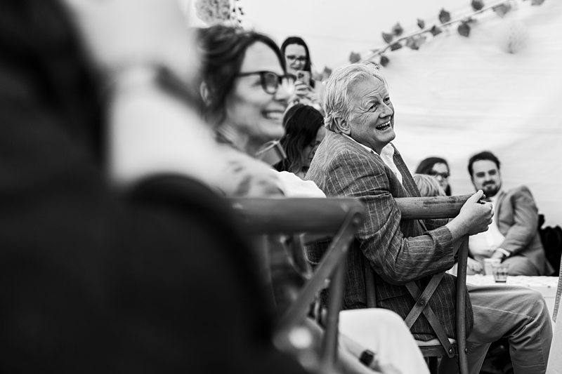 People smiling and laughing at a gathering.