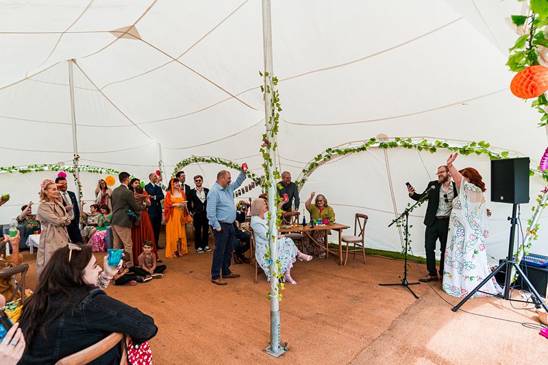 Group of people at tent-covered event.