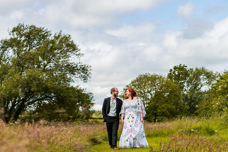 Couple walking in a grassy field