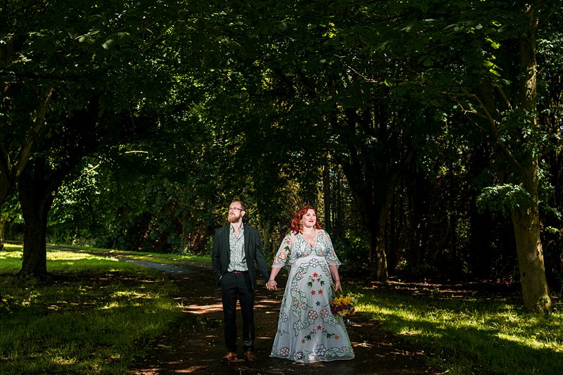 Couple walking through a sunlit forest path