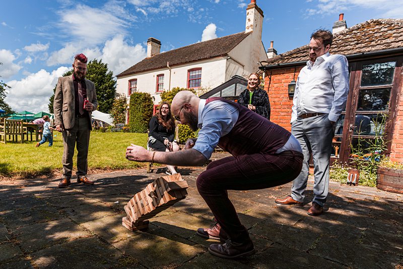 People playing outdoor Jenga game in garden.