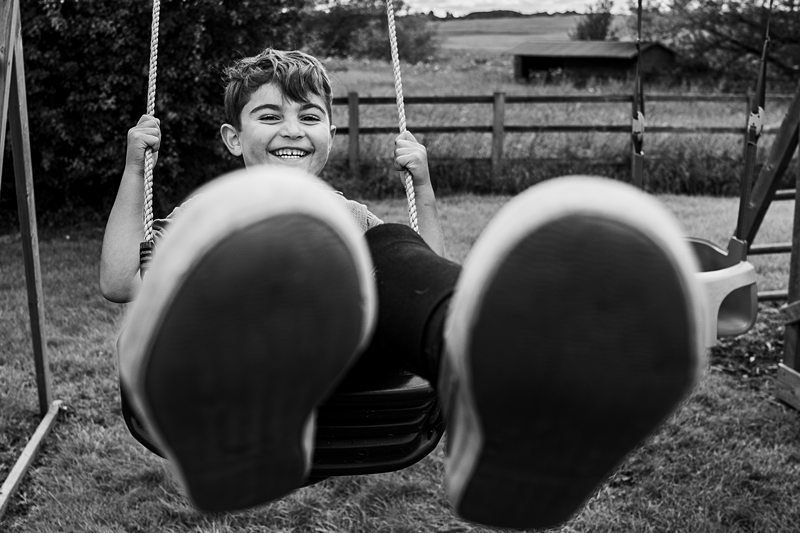 Happy boy on swings in park