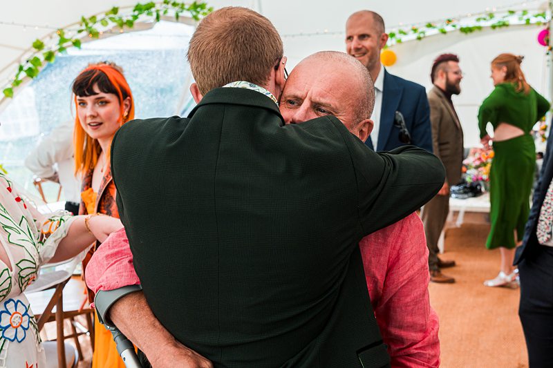Two men hugging at a social event.