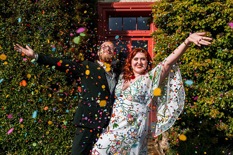 Happy couple celebrating with confetti outdoors