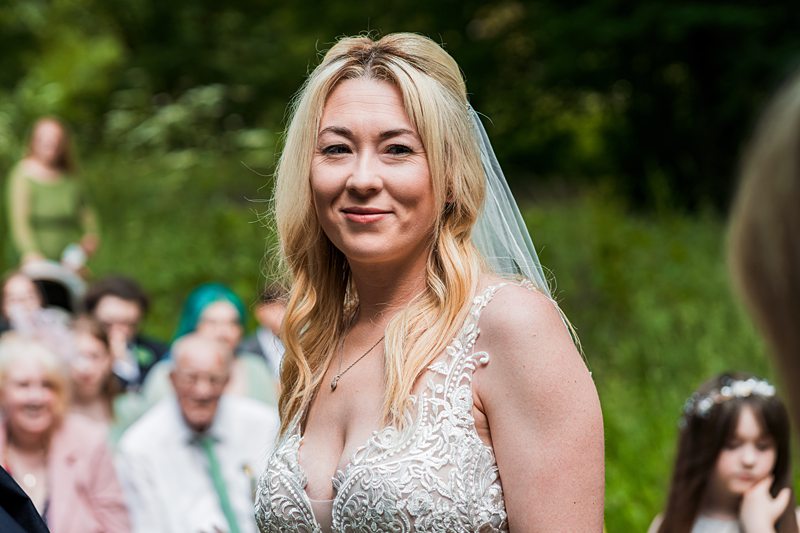 Bride smiling outdoors at wedding ceremony