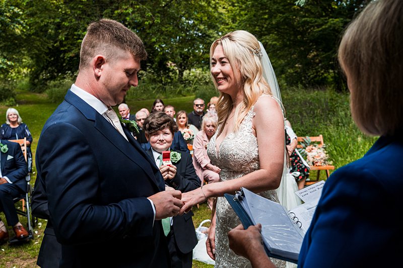 Outdoor wedding ceremony exchanging rings