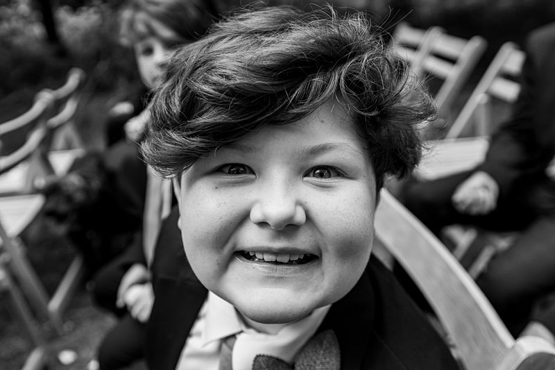 Smiling boy in suit at outdoor event.