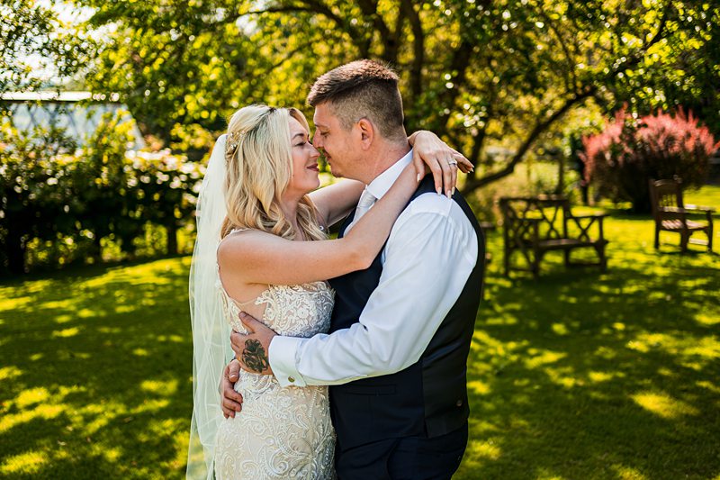 Bride and groom kissing in a garden