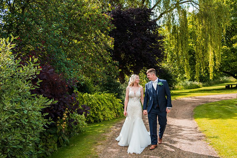 Bride and groom walking in a garden