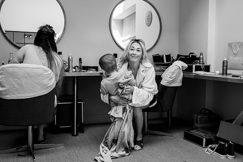 Two women getting ready, one holding a child.