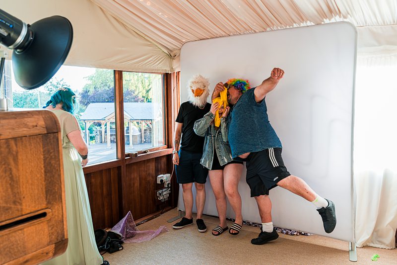 People with masks posing in photo booth.