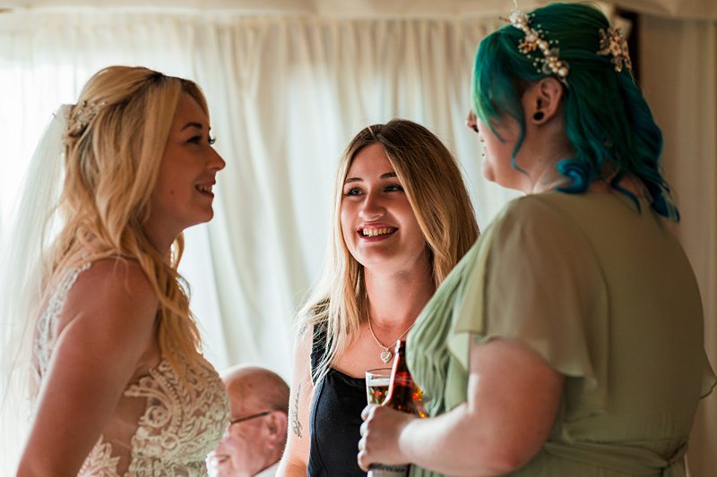 Three women smiling at a wedding reception