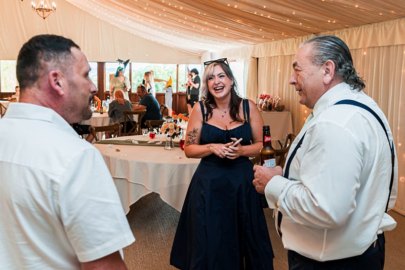 Guests laughing and chatting at a wedding reception.