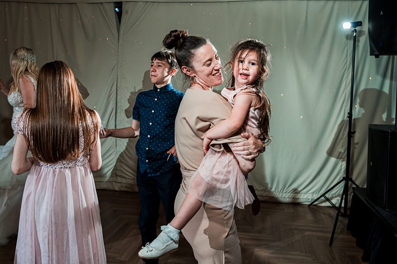 Woman dancing while holding a child.