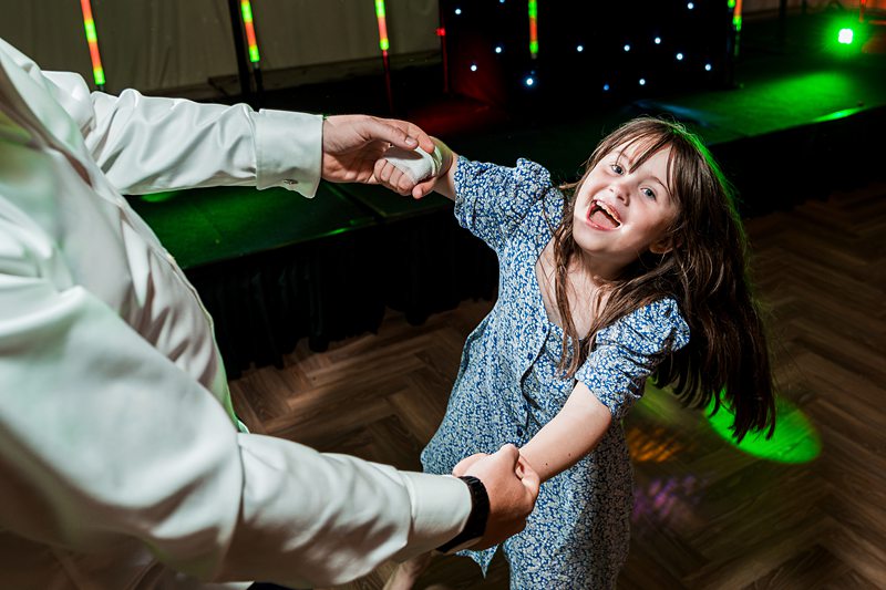 Girl dancing with adult at a party.