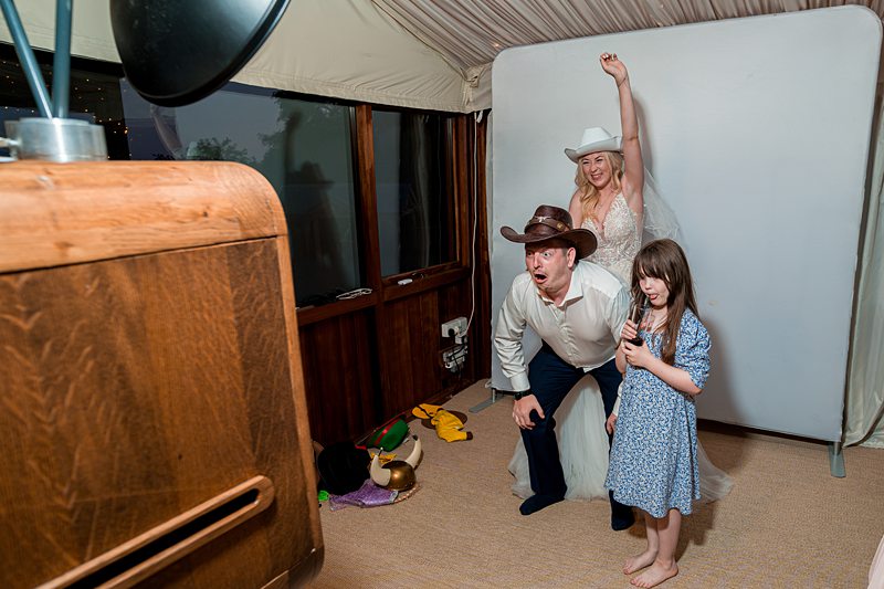 Family posing in cowboy hats, photo booth fun.