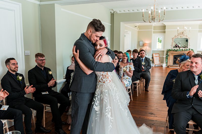 Bride and groom embrace during wedding ceremony.