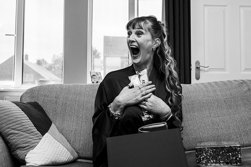 Woman surprised with gifts on sofa