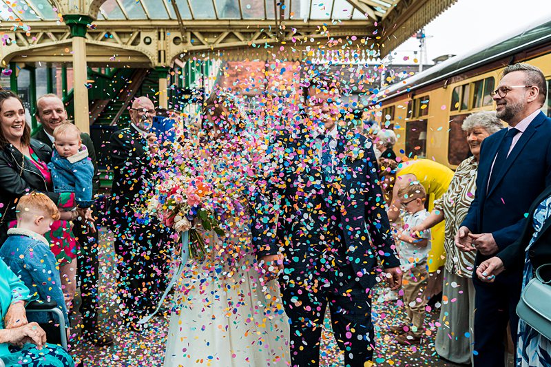 Bride and groom showered with colourful confetti.