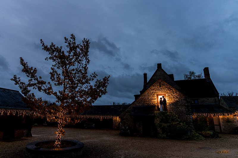 Romantic couple in doorway, evening lights, country house.