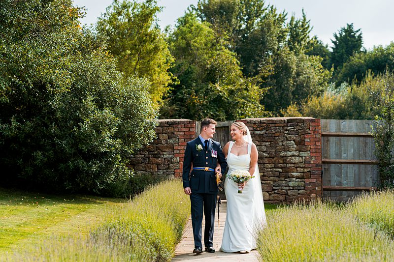 Bride and groom walking in garden path