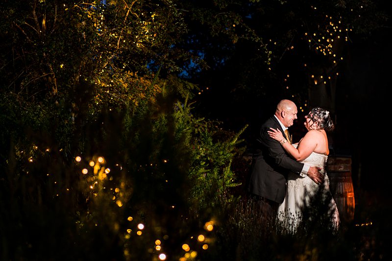 Couple dancing under fairy lights at night.