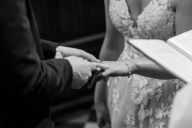 Bride and groom exchanging wedding rings.