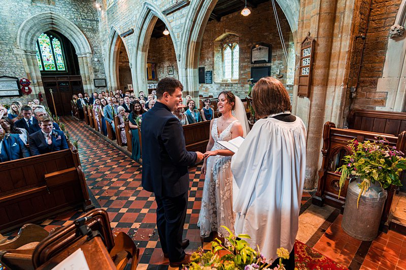 Bride and groom exchanging vows in church ceremony.