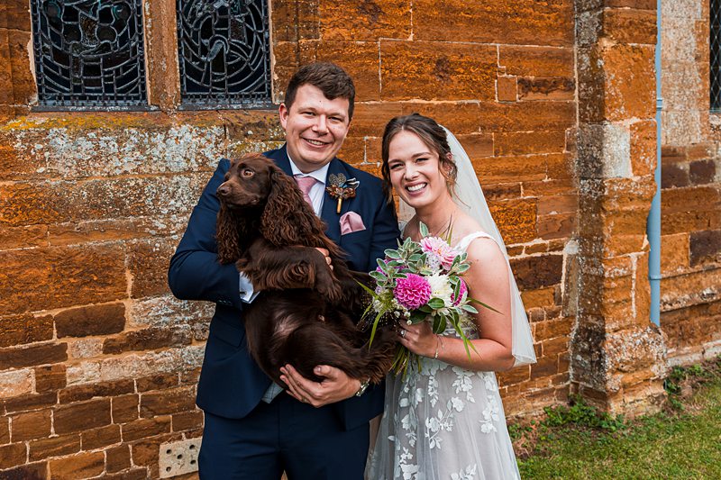 Couple with dog at wedding outside church