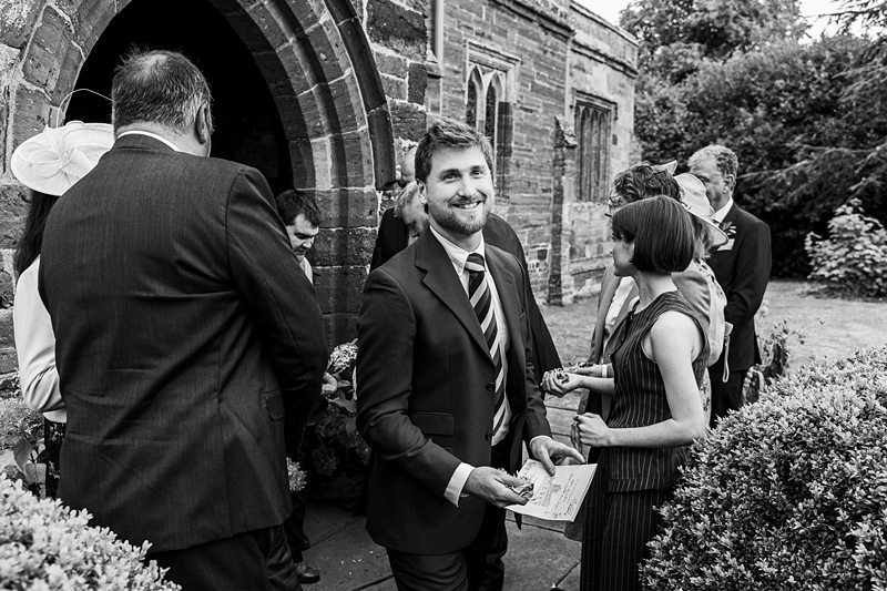 Guests chatting outside stone church entrance.