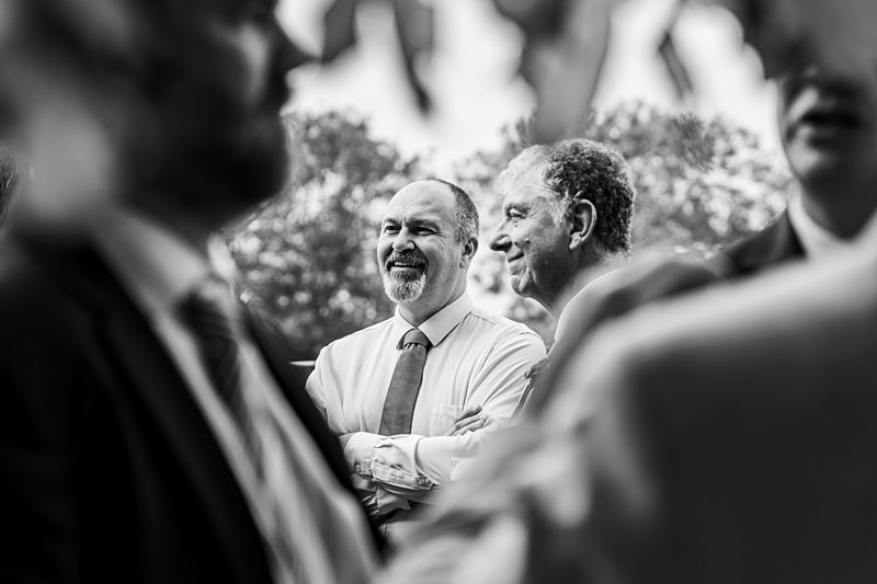 Men in discussion outdoors, black and white photo.
