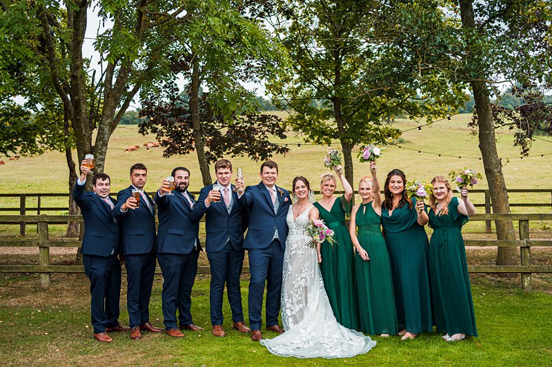 Wedding party celebrating in countryside setting.