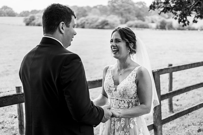 Bride and groom smiling in countryside setting
