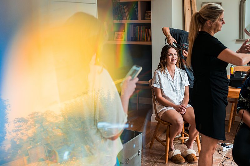 Bride getting ready with hairstylist and friends