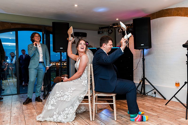 Bride and groom play wedding shoe game.