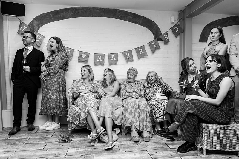 Guests celebrating at a wedding under 'Just Married' banner.