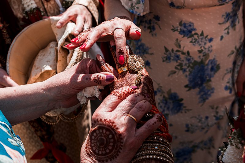 Decorated hands with henna and jewellery close-up.