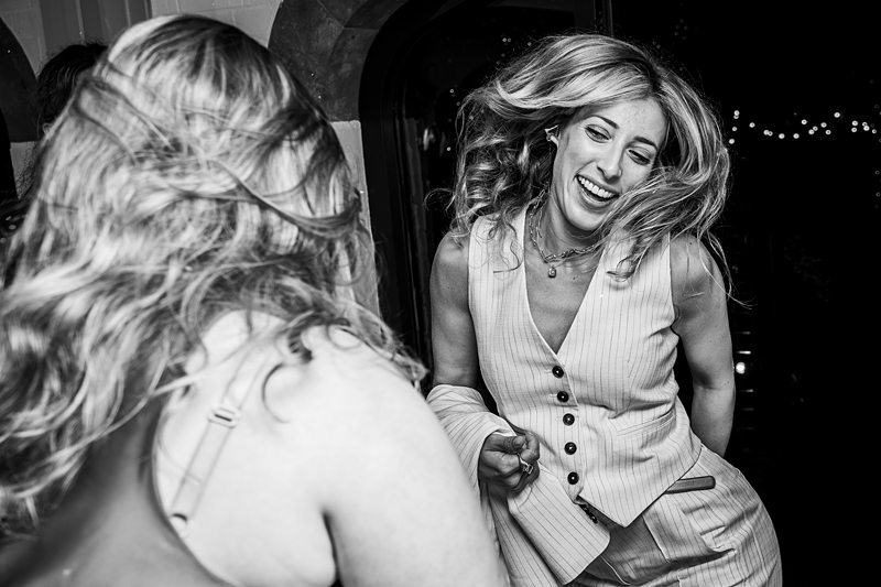 Two women smiling and dancing at a party.