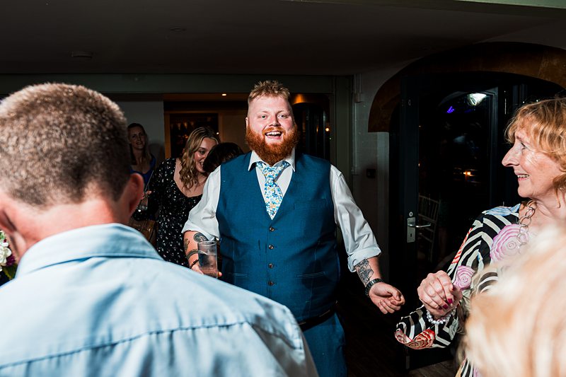 Man celebrating at a party with friends indoors.