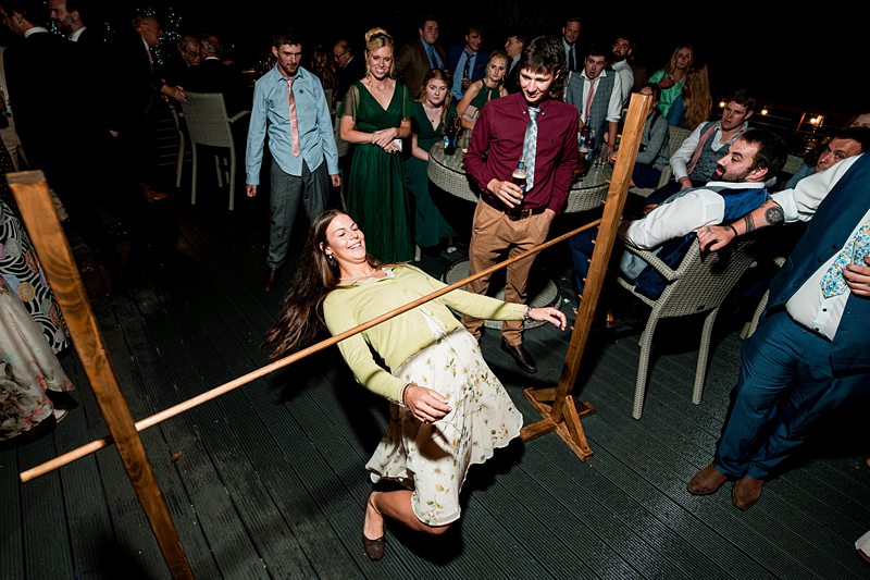 Group enjoying limbo game at evening event.