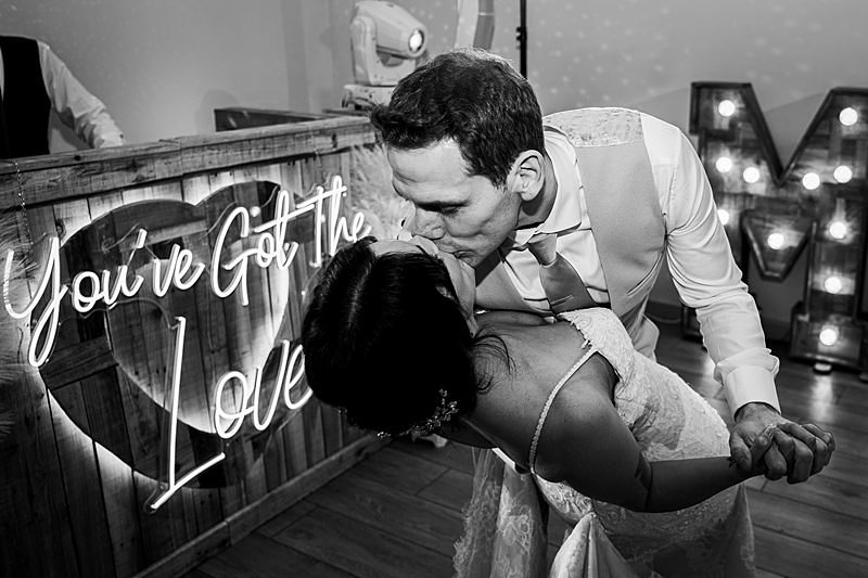 Bride and groom kissing at wedding reception.