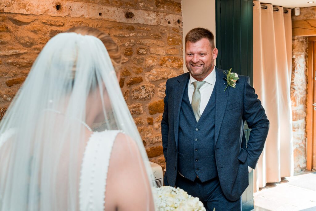 Bride and groom smiling in rustic venue.