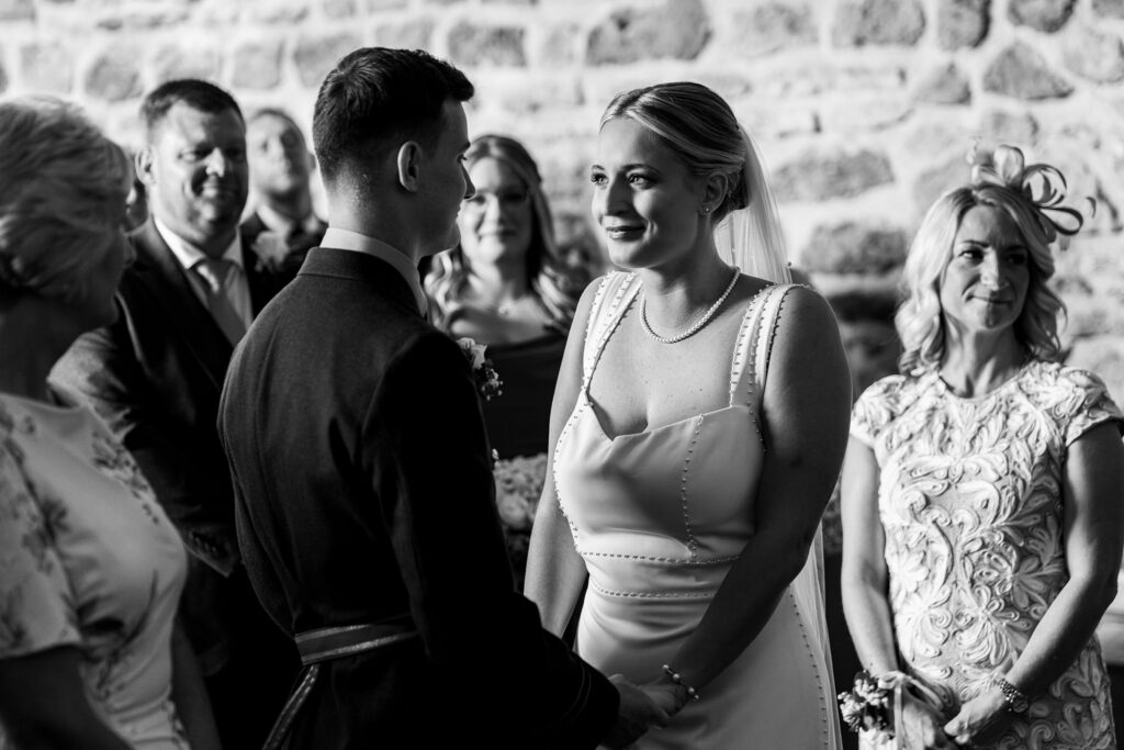 Bride and groom smiling during wedding ceremony.