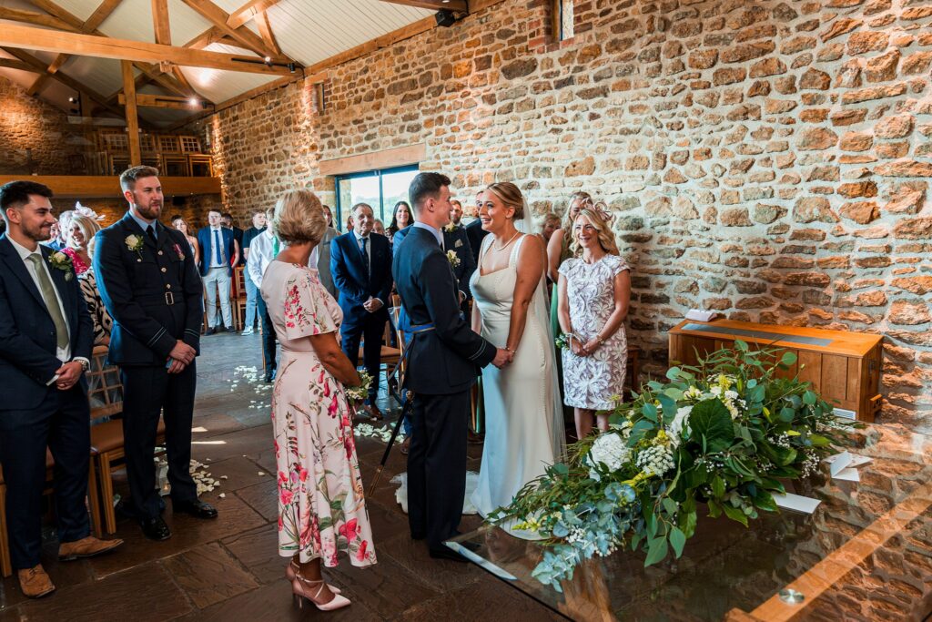 Couple exchanging vows in rustic wedding ceremony.