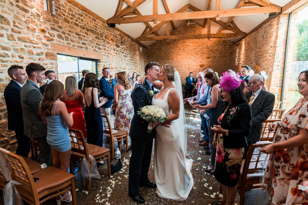 Bride and groom kissing in a stone chapel wedding.