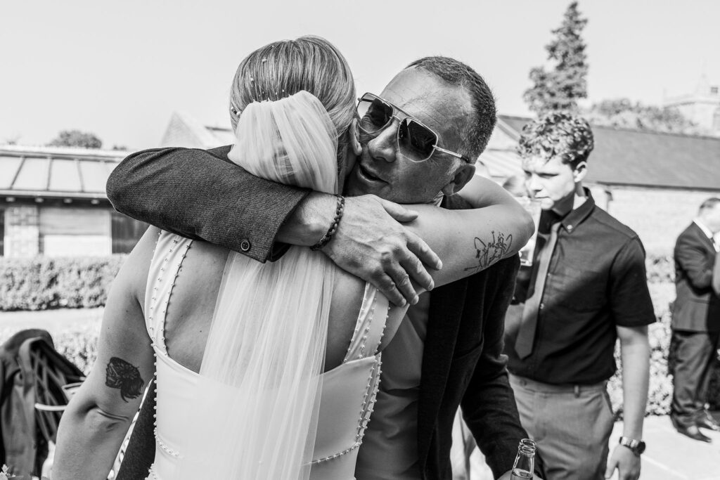 Bride hugging guest at outdoor wedding reception