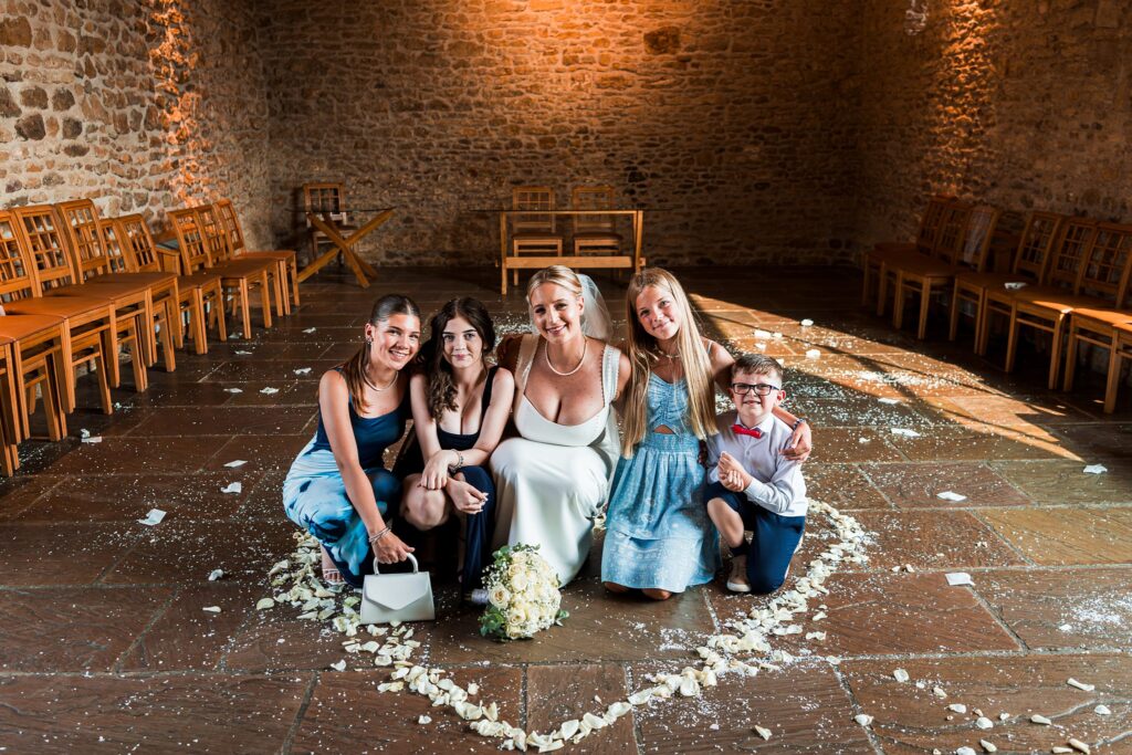 Bride with children in rustic wedding venue.